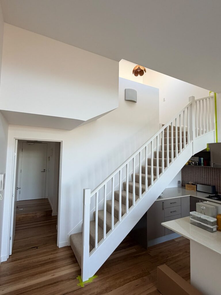 Staircase balustrade repainted in crisp white by AKD Painting, Sydney home