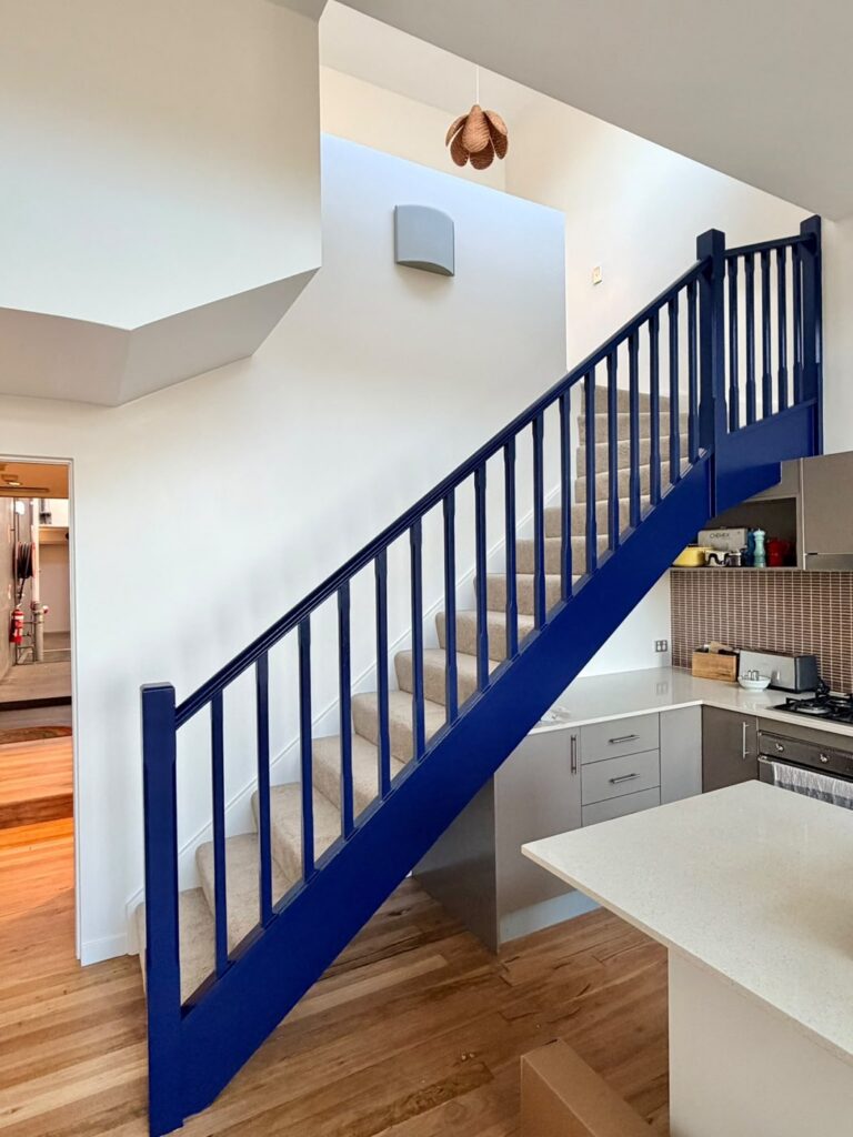 Timber staircase with dated blue painted balustrade before repainting, Sydney home