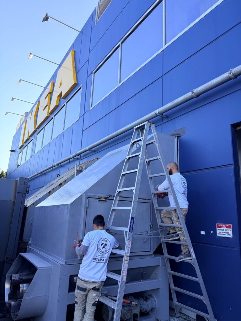 AKD Painting team applying protective coating to a compactor at IKEA Rhodes