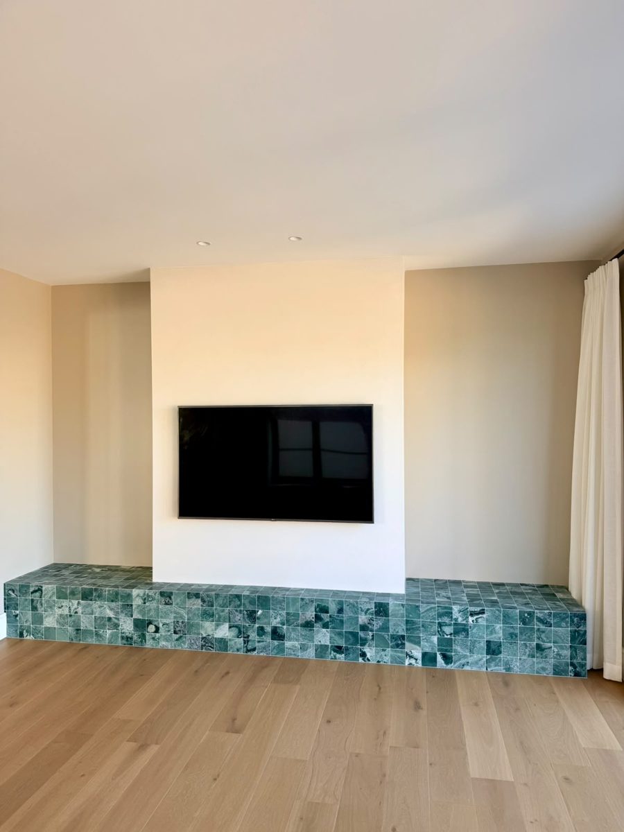Living room feature wall with green tiled hearth and freshly painted walls in an Annandale renovation