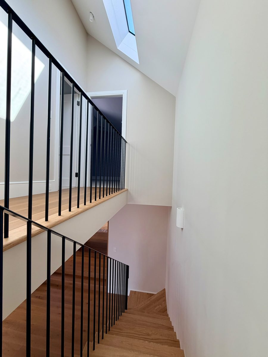 Stair void with skylight and black balustrade, walls painted white in an Annandale renovation