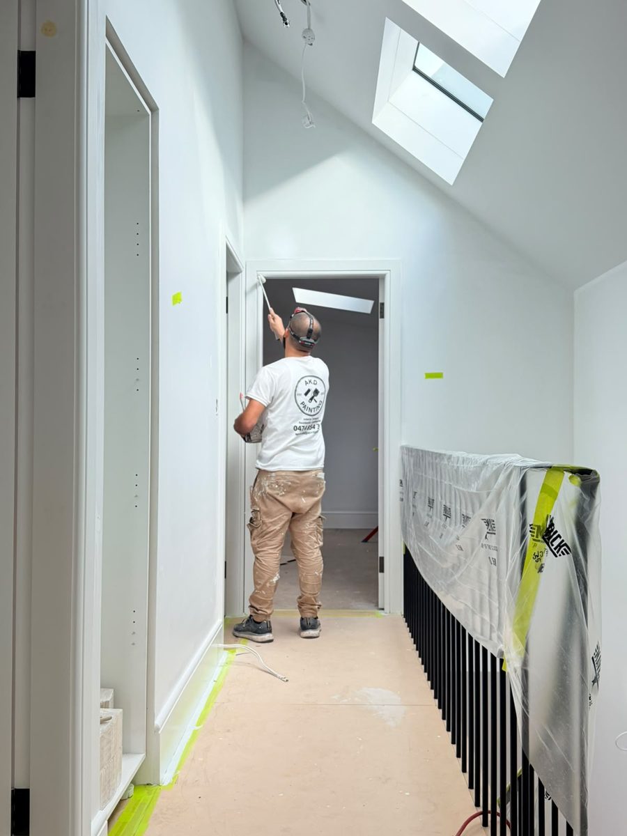 AKD painter on the upstairs landing of an Annandale home, skylight wall cut in and balustrade wrapped