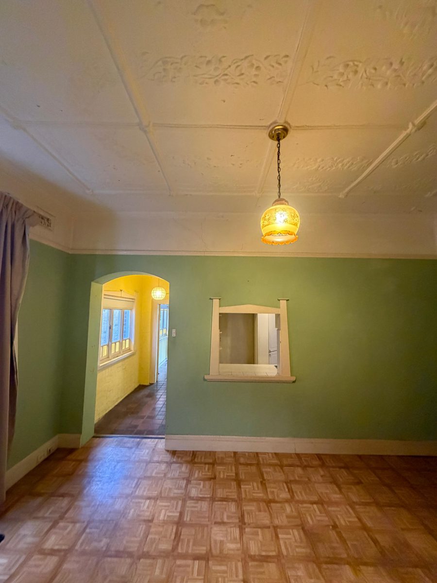 Federation living room in Five Dock before painting, mint green walls, pressed metal ceiling and arched opening